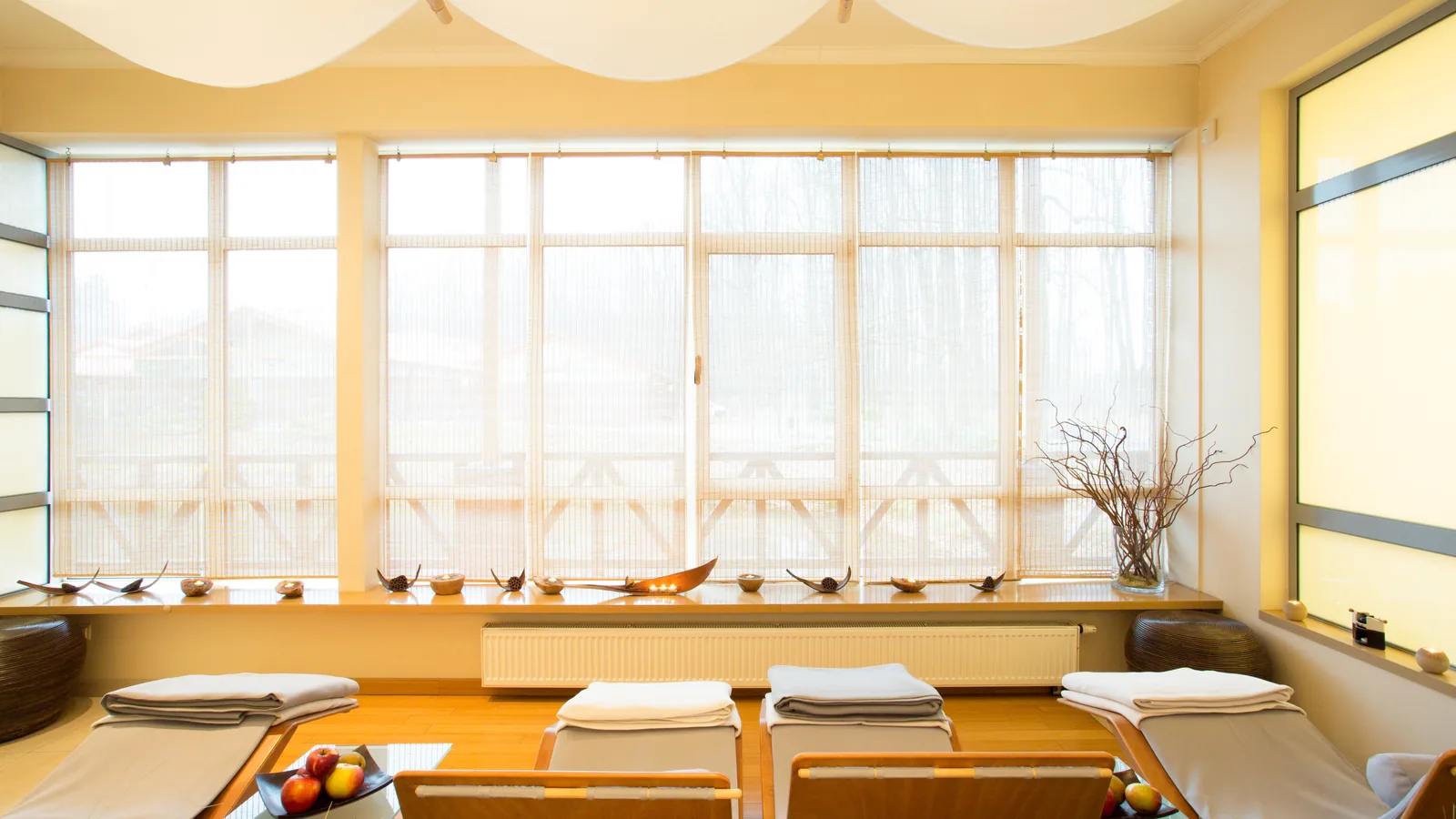 Luxury spa relaxation room with treatment loungers and natural light