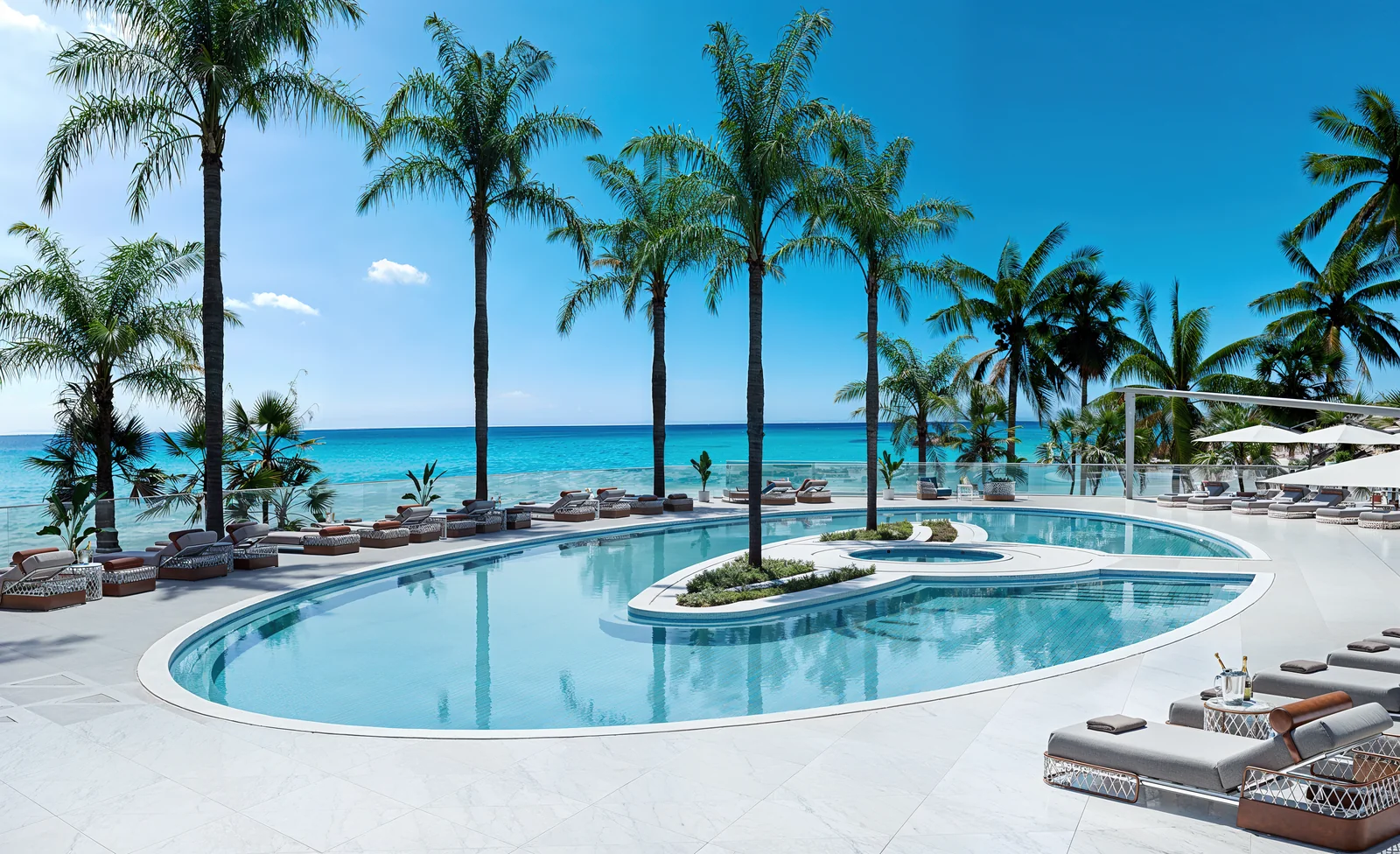 Bentley Residences oceanfront resort pool deck lined with palms, Sunny Isles Beach