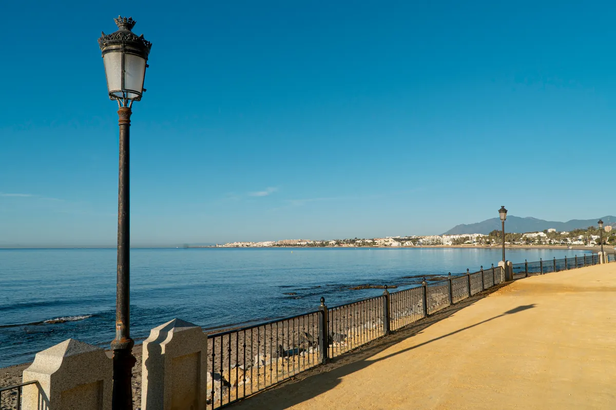 Marbella seafront promenade on Spain's Costa del Sol, with the coastline and mountains beyond