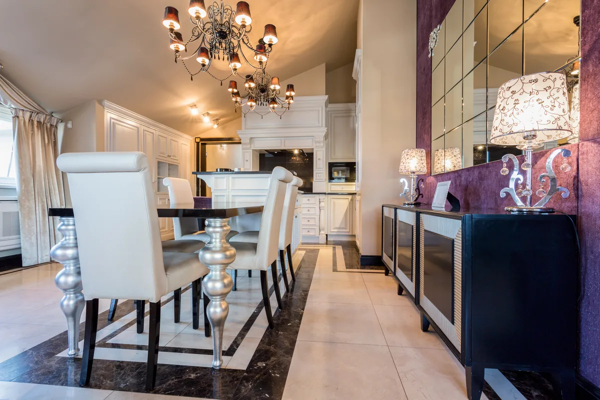 Opulent branded-residence dining room with chandelier, marble floor and mirrored wall