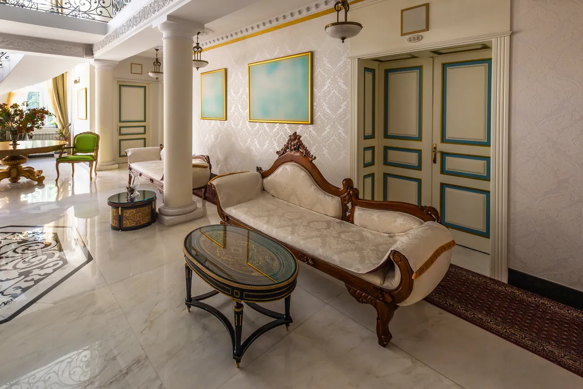 Opulent classical interior with carved gilt furniture, damask walls and a marble floor