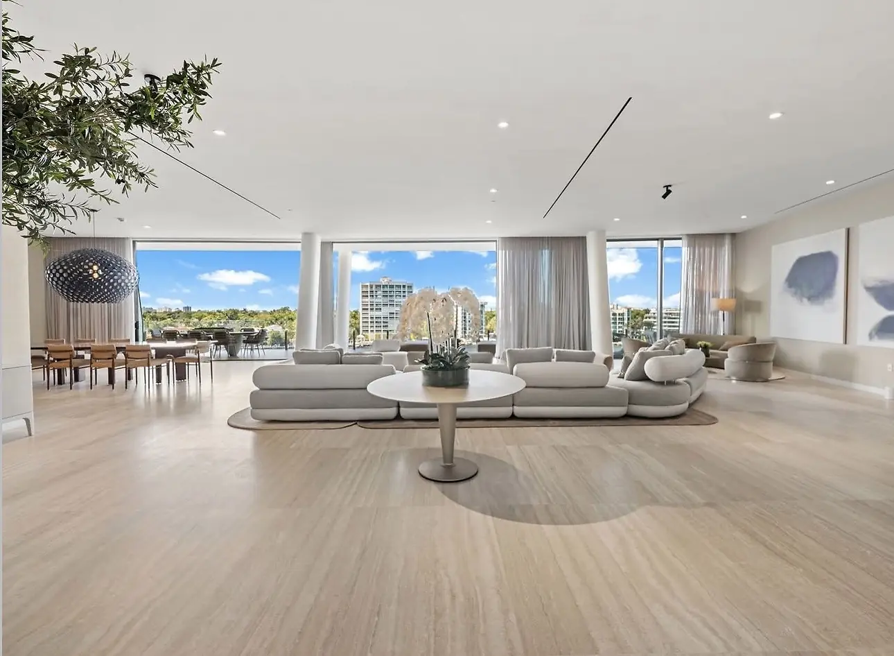 Vita Grove Isle penthouse living and dining room with floor-to-ceiling glass and bay views