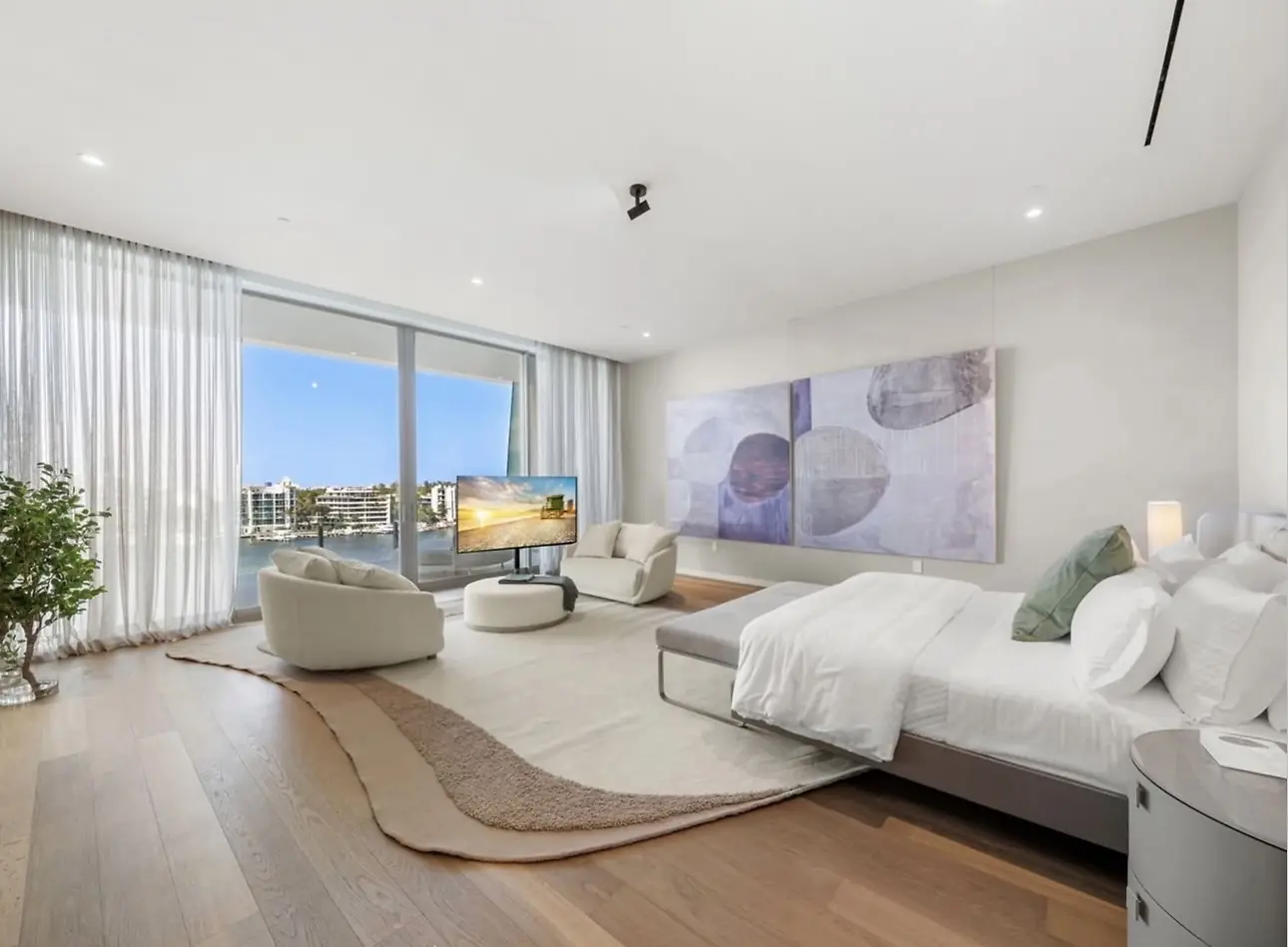 Vita Grove Isle penthouse bedroom suite with floor-to-ceiling glass and Biscayne Bay views