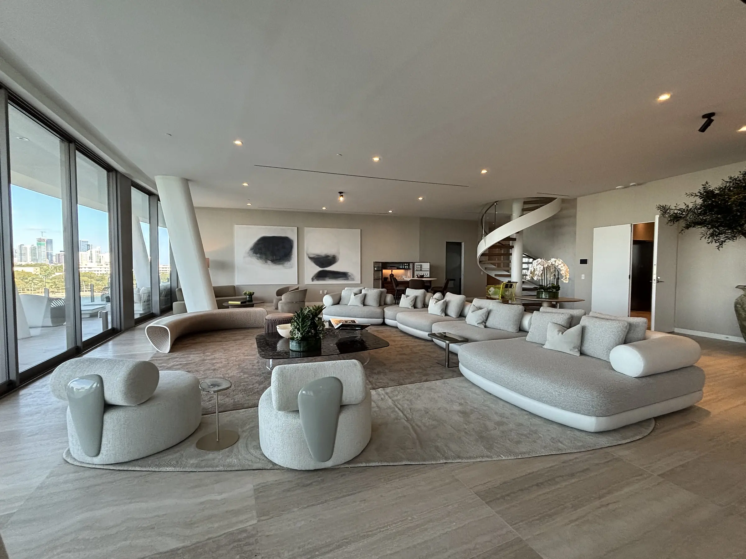 Vita Grove Isle penthouse living room with sculptural seating and curved staircase