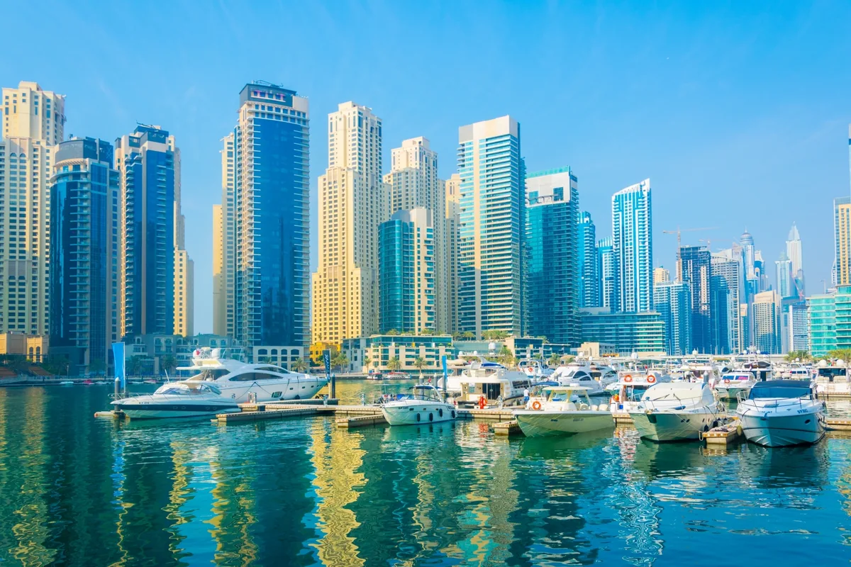 Dense cluster of high-rise towers along the waterfront of Dubai Marina, UAE, with yachts moored in the foreground