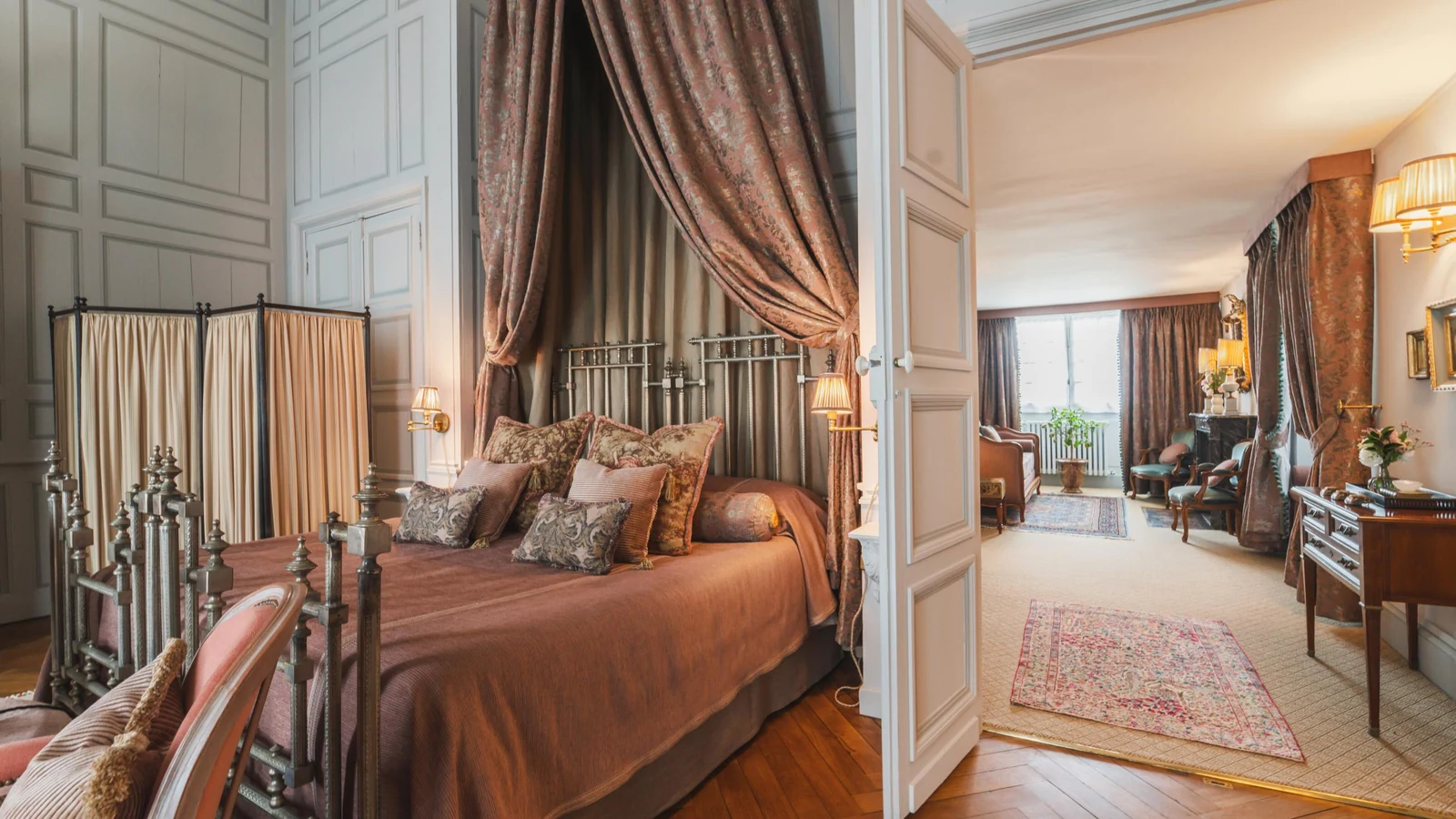 Private château estate bedroom suite with canopied bed opening to a private sitting room