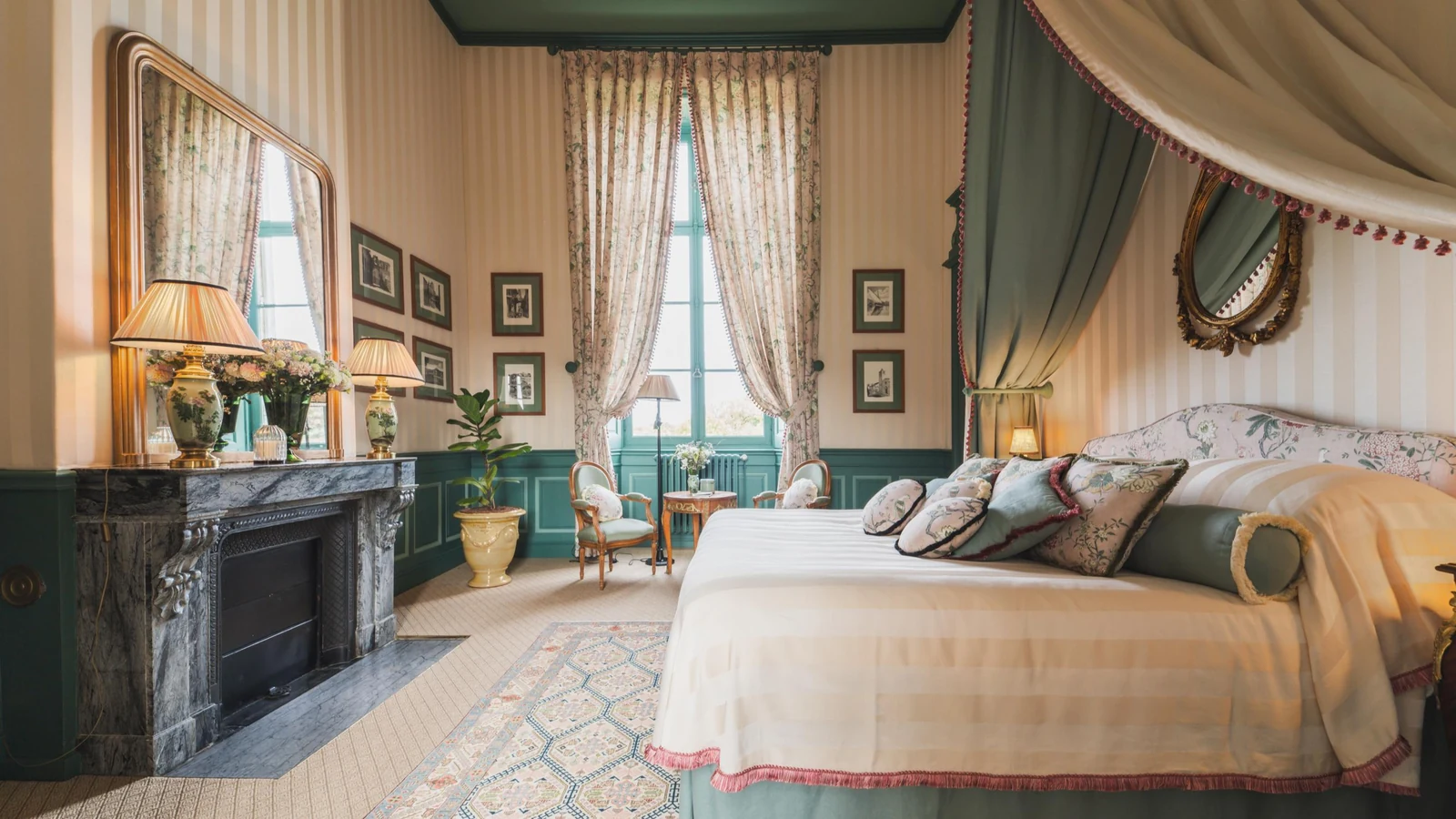 Private château estate bedroom with green panelling, marble fireplace and canopied bed
