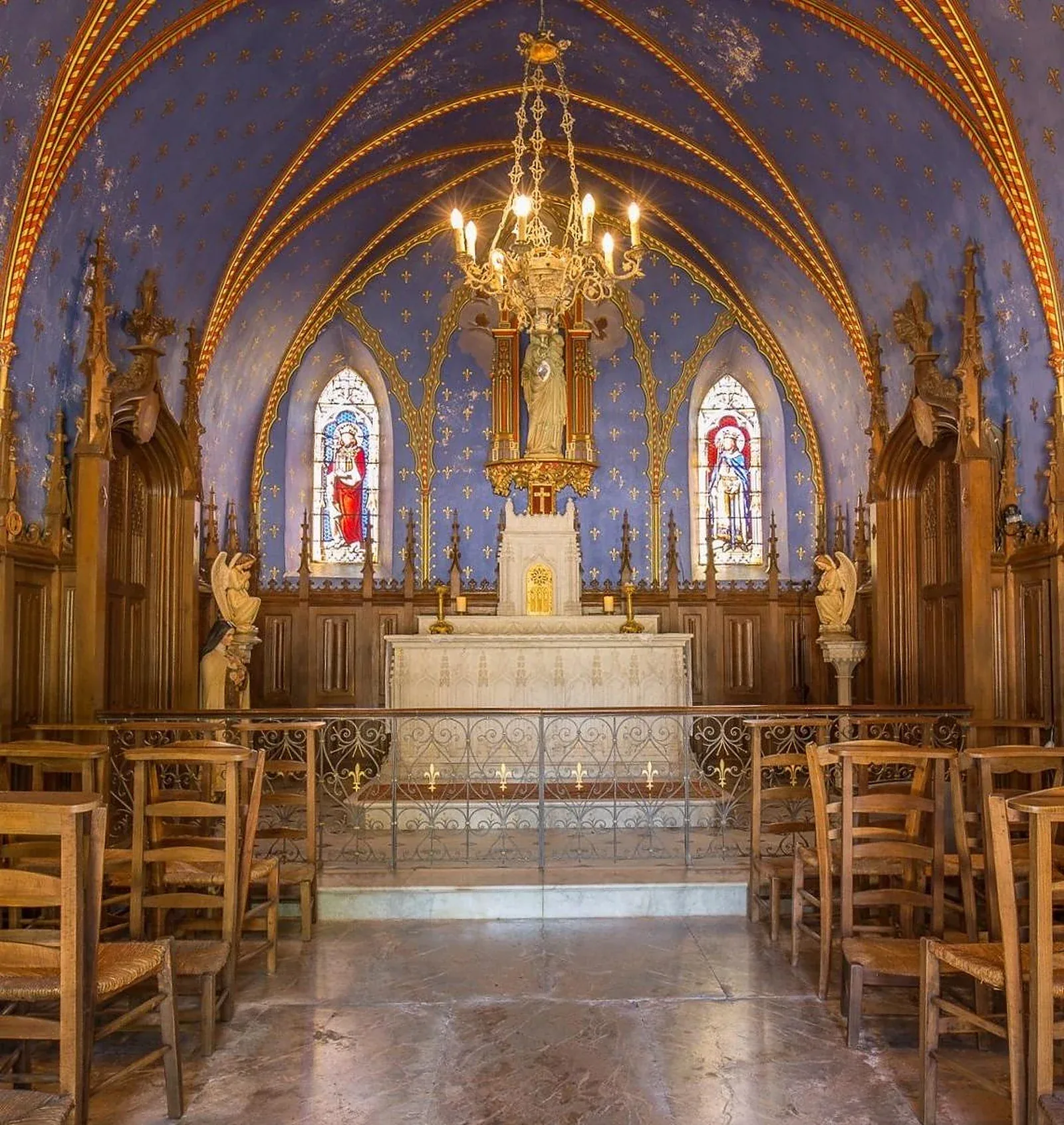 Private château estate chapel with vaulted ceiling, stained glass and carved oak stalls