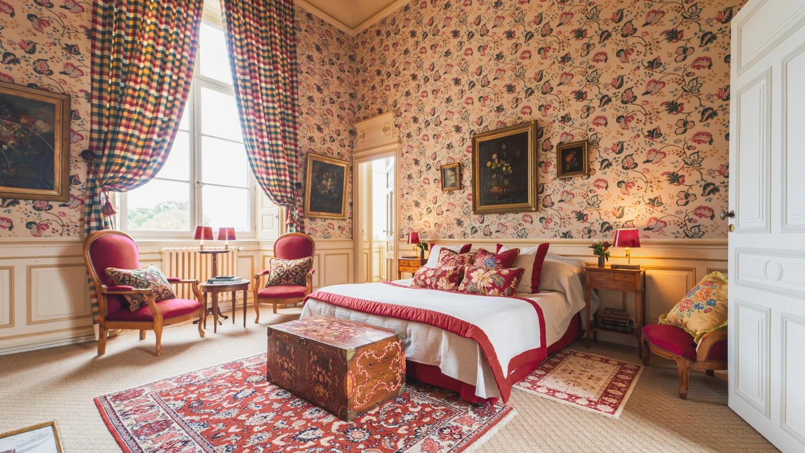 Private château estate bedroom with floral wallpaper, oil paintings and checked curtains
