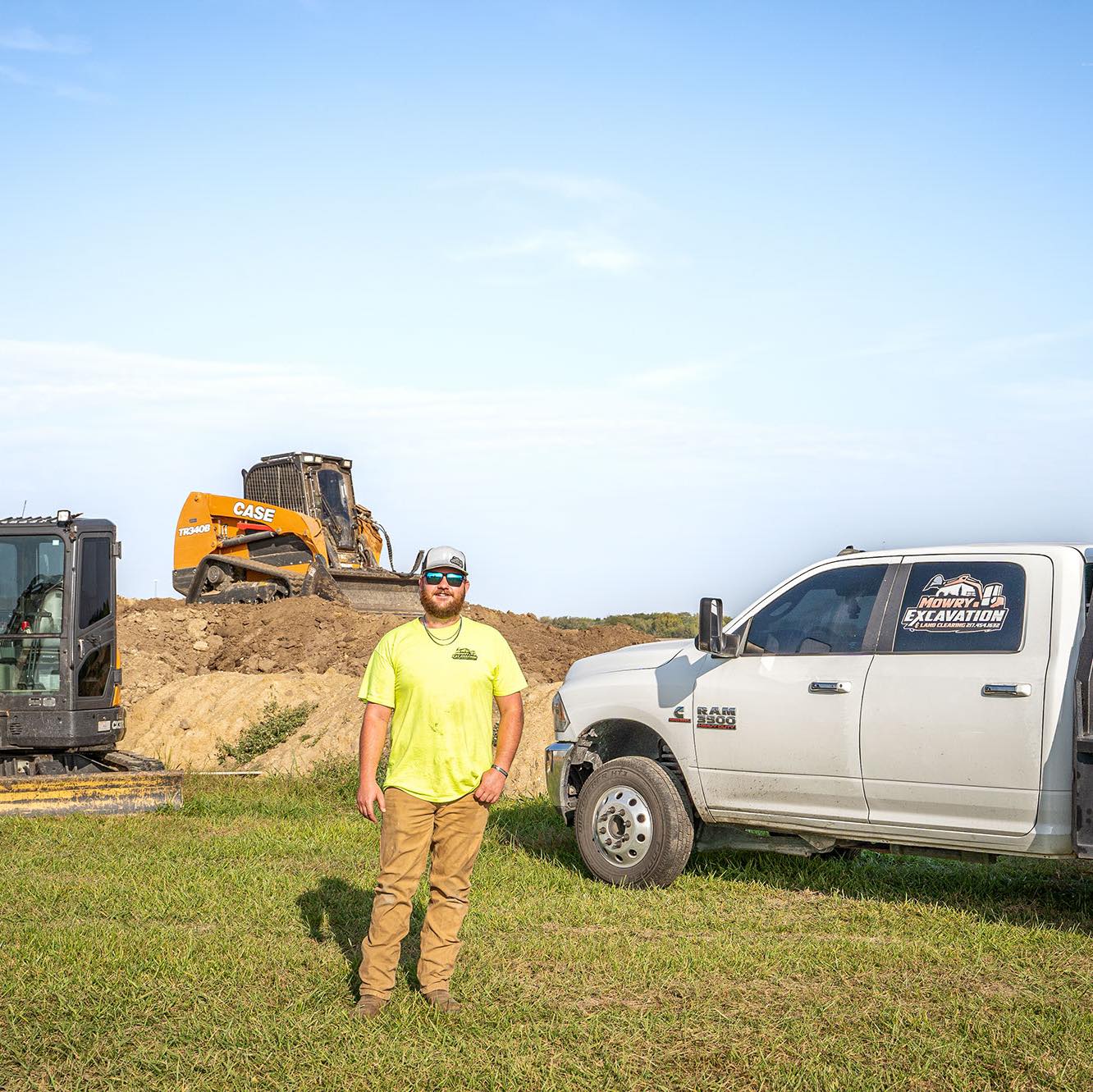 Mowry Excavation team member in a high-visibility shirt standing by a company truck at an Illinois job site
