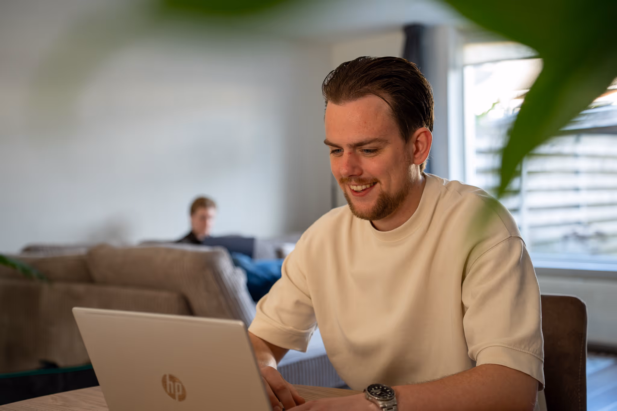 Stan van SENT Marketing werkt geconcentreerd en met plezier aan een laptop, klaar om nieuwe marketingkansen voor klanten te realiseren.