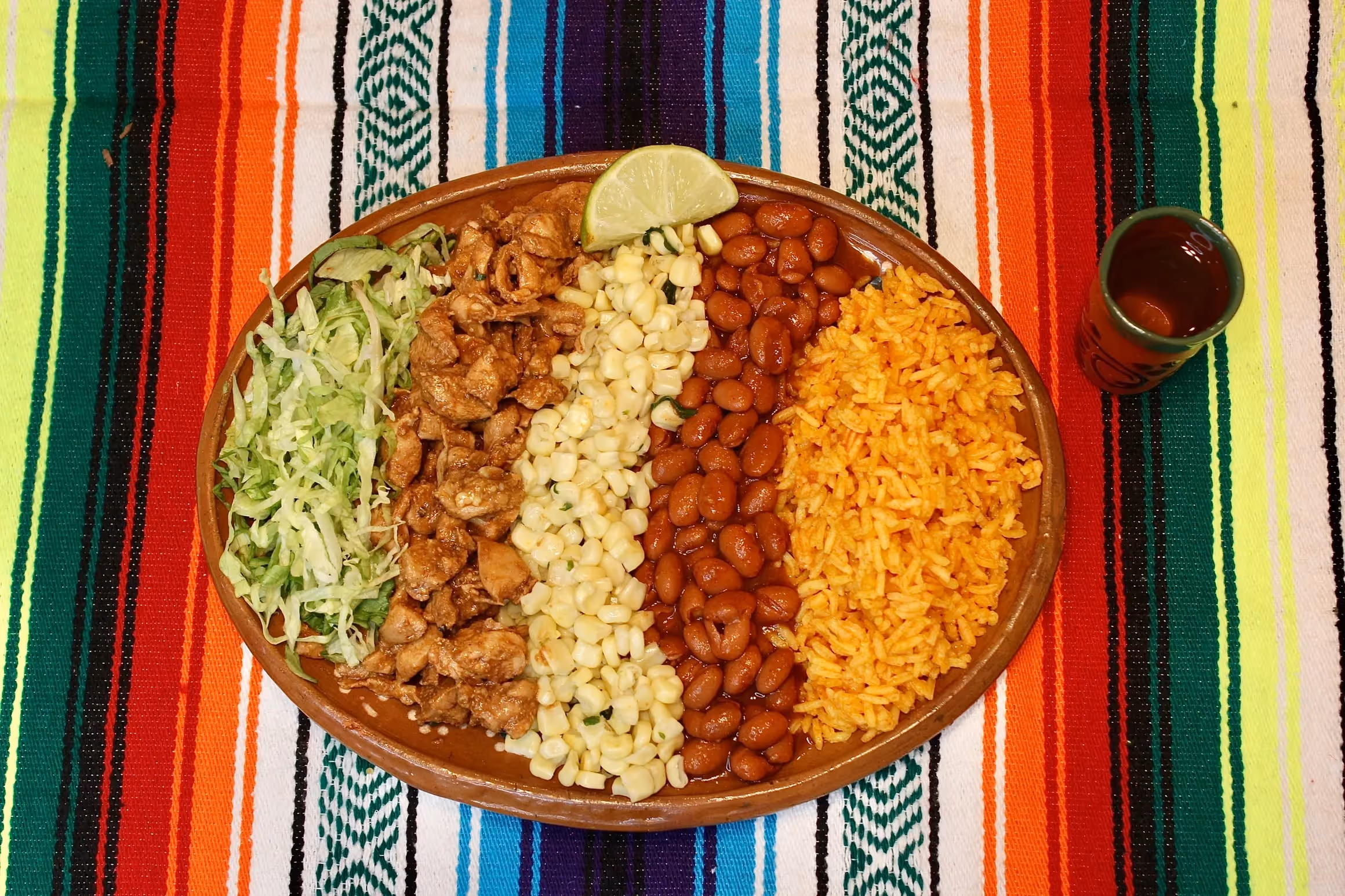 plate with lettuce, steak, corn, beans, and Mexican rice