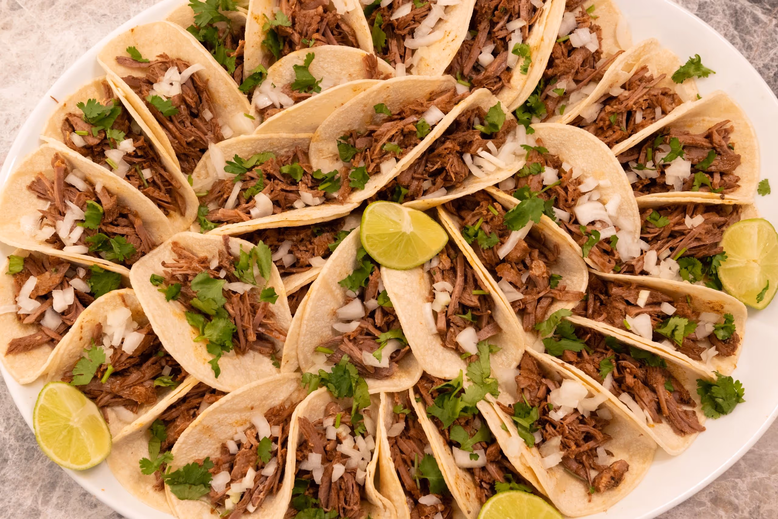 tray of authentic Mexican tacos with onions and cilantro on top