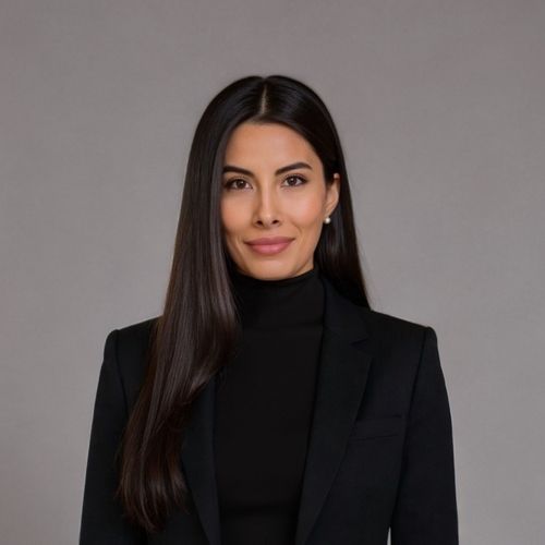 Professional woman with long dark hair wearing a black turtleneck and dark blazer against a gray background.