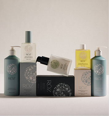 RŌZ – muted green and neutral haircare bottles and boxes arranged in a clean studio display.