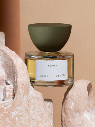 Maison d’Etto – Canaan perfume bottle with matte green cap placed between pale stone formations.