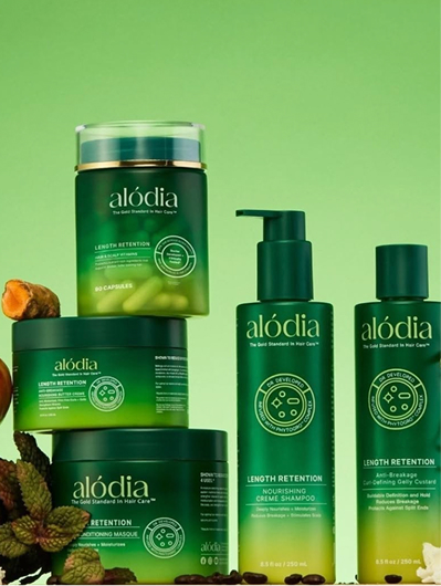 Alodia – green haircare bottles and treatment jars arranged against a vibrant green studio background.