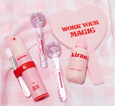 Kiramoon – pink skincare products and heart-shaped “Work Your Magic” case arranged on a gingham background.