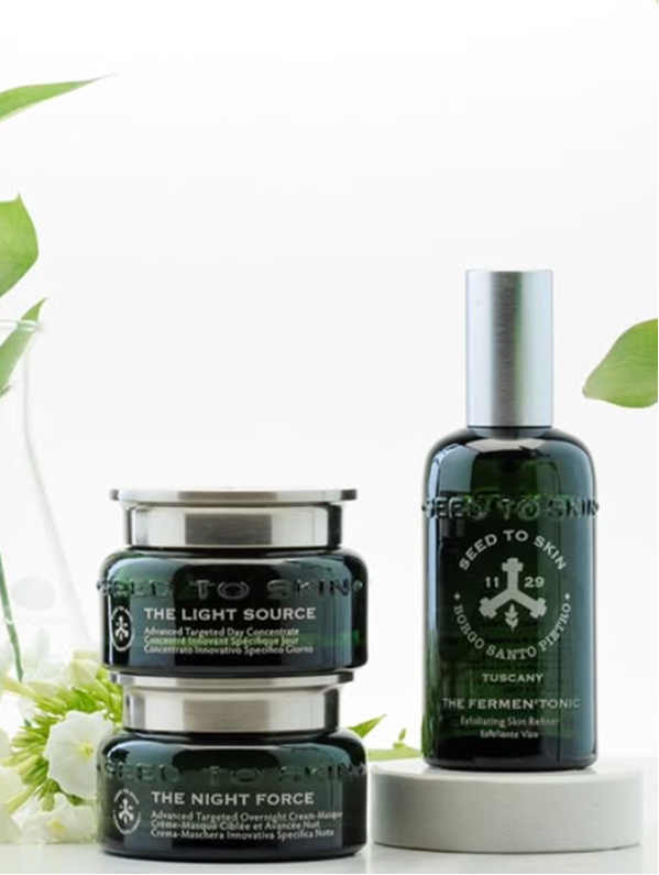 Seed to Skin – dark green glass skincare jars and tonic bottle styled with soft natural light and foliage.