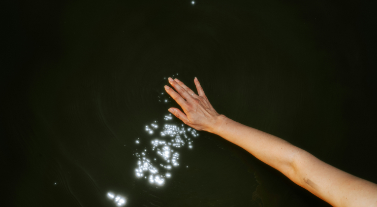 Hand reaching into water with ripples for one-to-one founder coaching at Constellar.