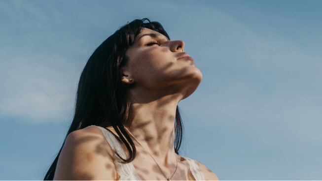 Woman looking upward in natural light, representing Constellar founder retreats and reflection.