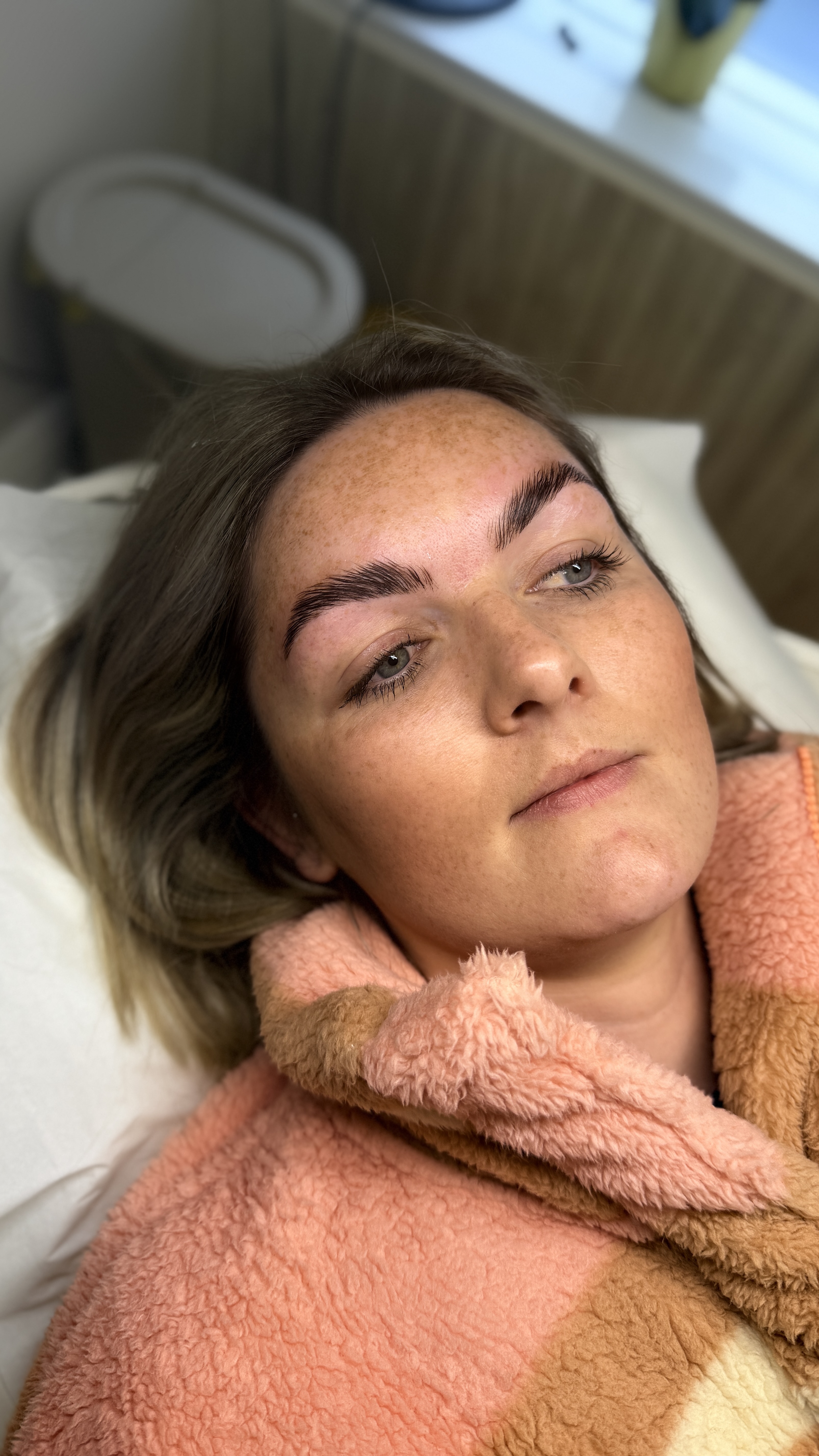 Woman laying on treatment bed at Ori Studio
