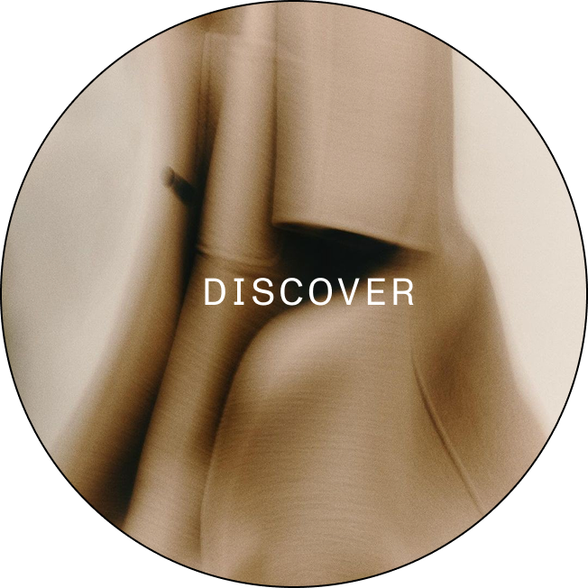 Blurred close-up of beige fabric folds with the word DISCOVER in white capital letters.