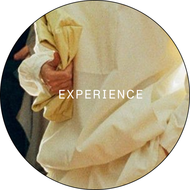 Close-up of a person in light beige clothing holding a folded fabric with the word EXPERIENCE overlaid.