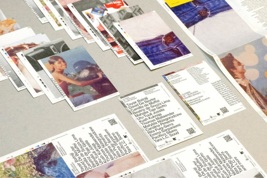 Print sheets laid out on a flat surface featuring portraits, colorful images, and text blocks with lists of names, likely proofs for a publication.