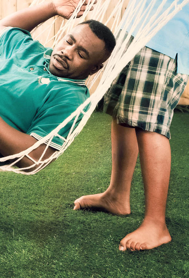 Children lifting father in hammock like a pinata in backyard scene, Ontario Power Generation campaign.