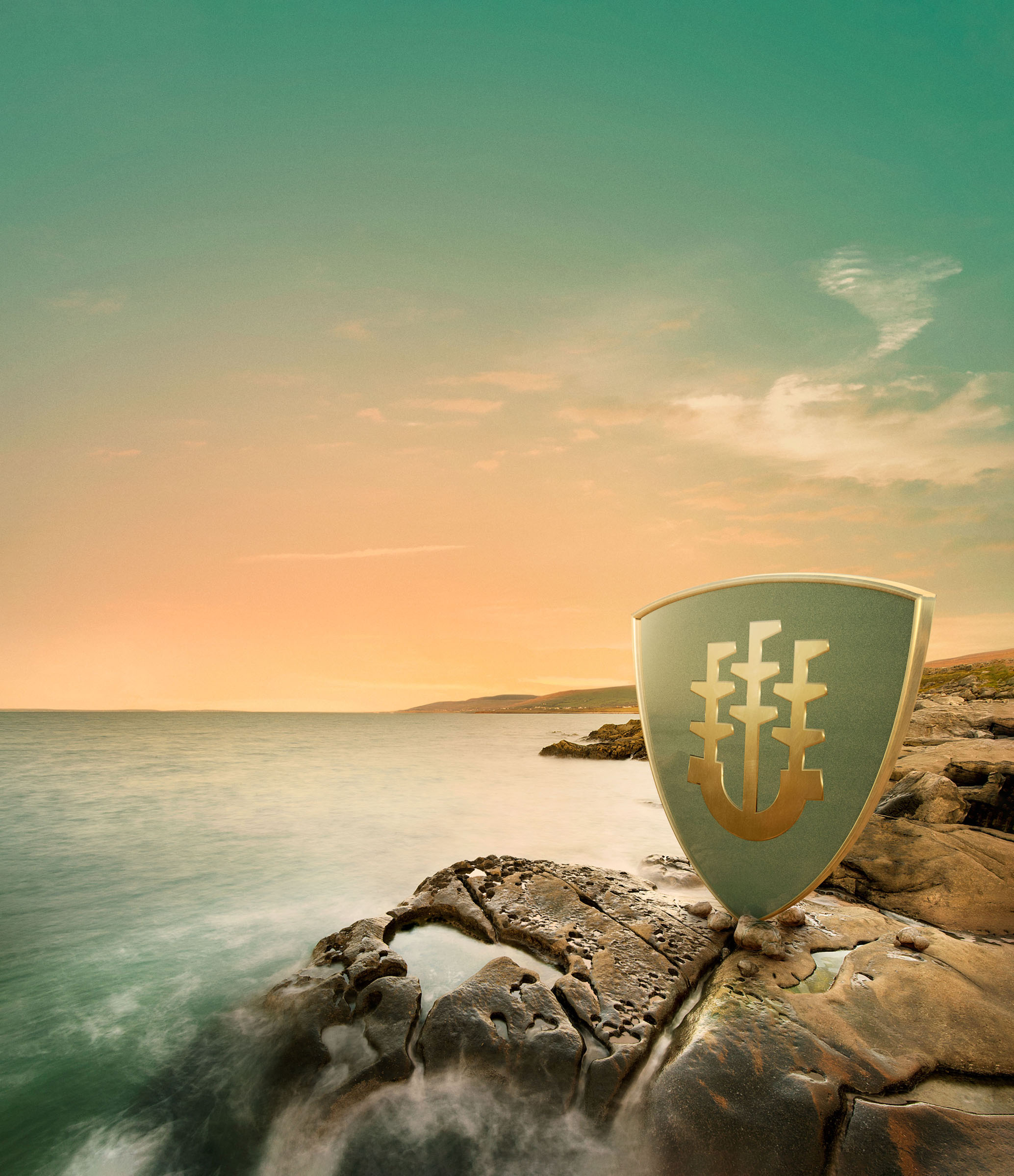 Shield emblem standing on rocky coastal shoreline at sunset, Sentry Investments campaign