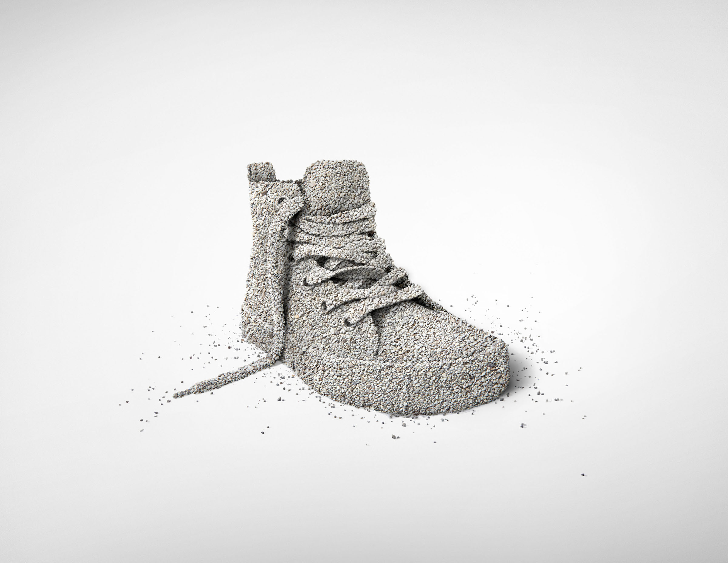 Sneaker sculpture made from cat litter with laces on white background, Royal Canin campaign.