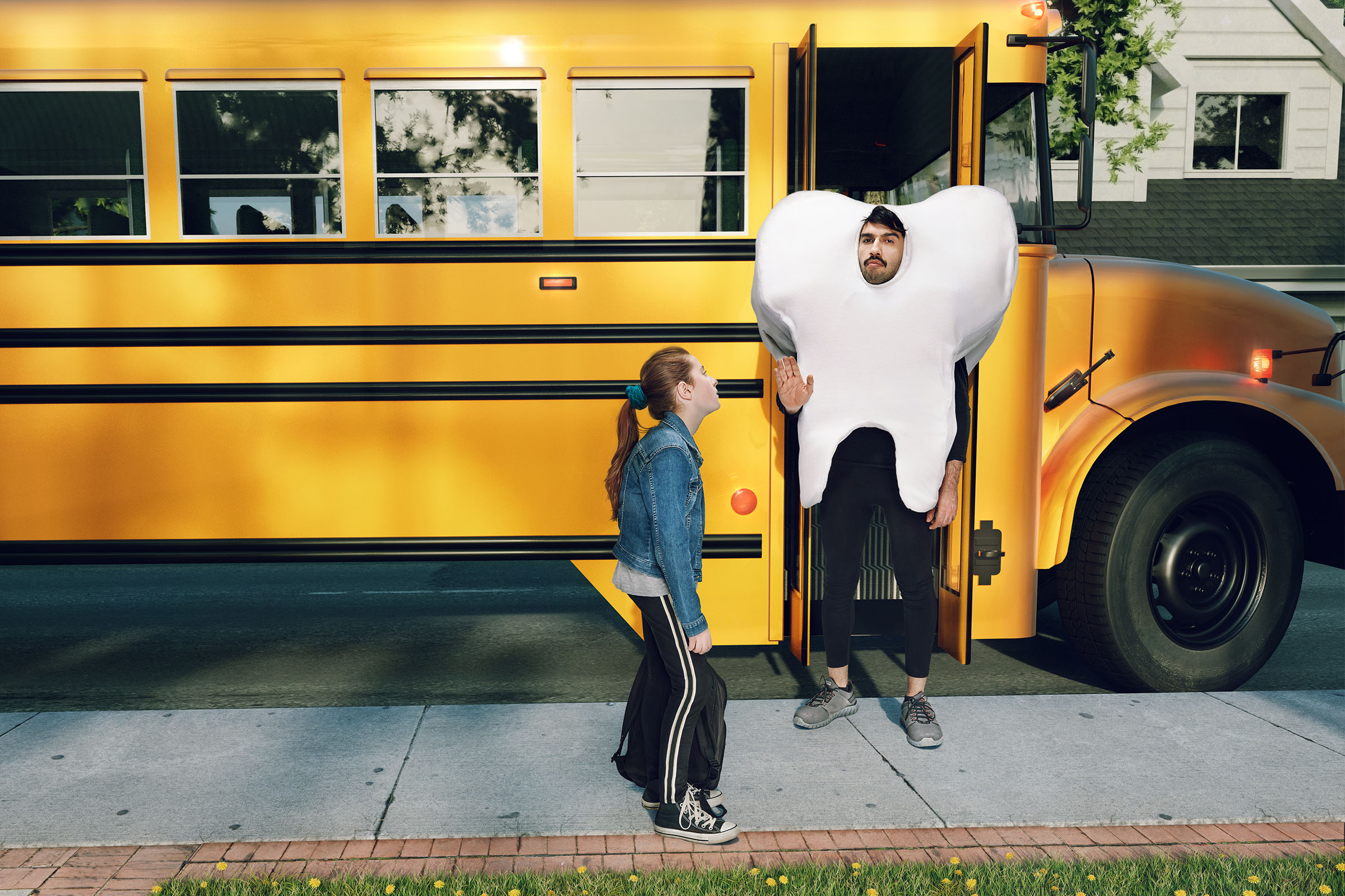 Person in tooth costume blocking student boarding yellow school bus, Ontario Dental Association campaign