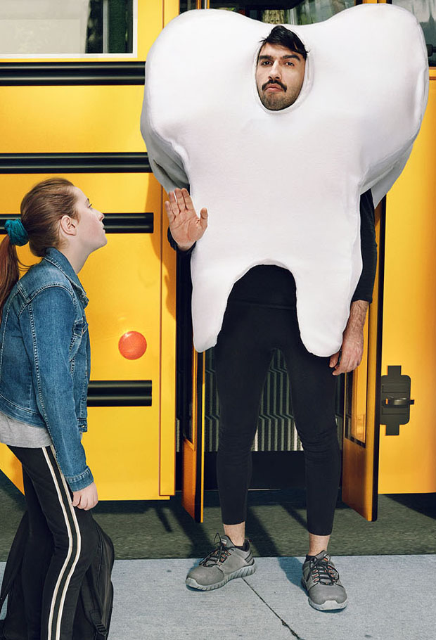 Tooth costume character standing in school bus doorway beside student, Ontario Dental Association campaign