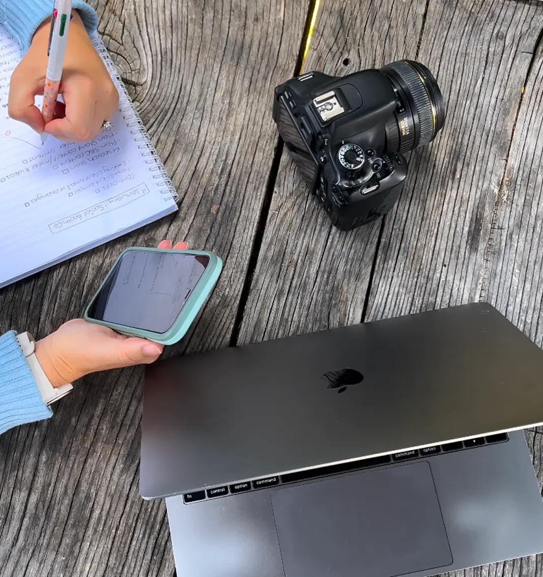 A lady is writing notes using her phone as a note sourse