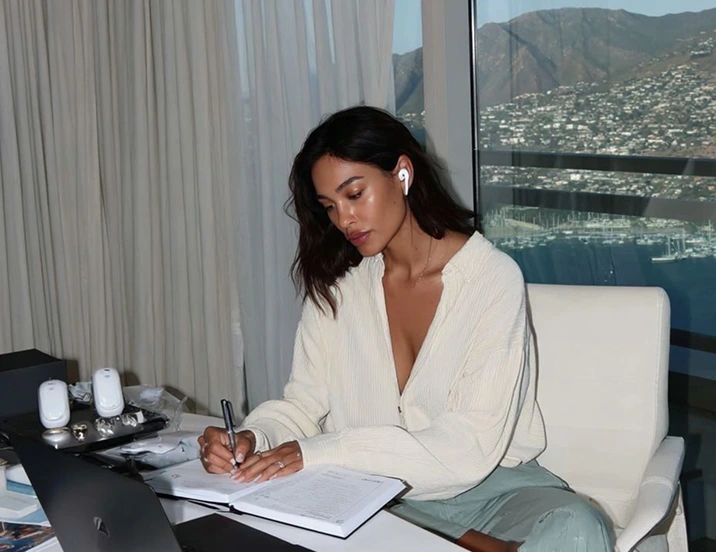A girl is taking notes while sitting at the desk
