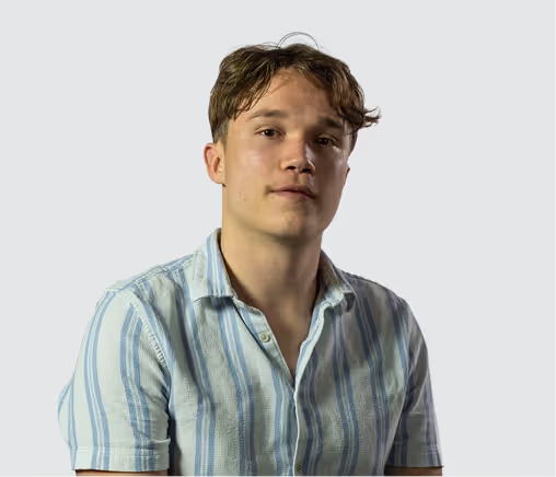Jeune homme aux cheveux bruns courts portant une chemise à rayures bleues et blanches sur fond gris clair.