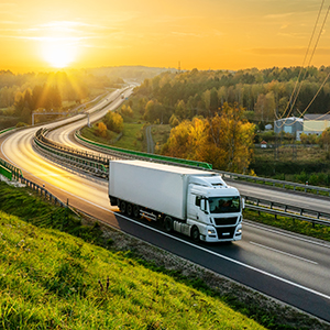 Freight truck driving on road at sunest