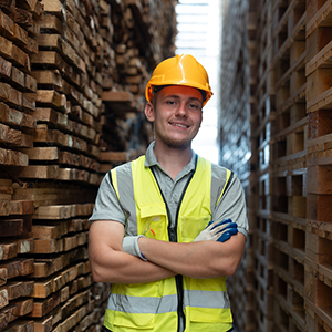 Male site worker stood in front of pallets 
