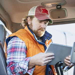 Male driver in truck cab on a tablet