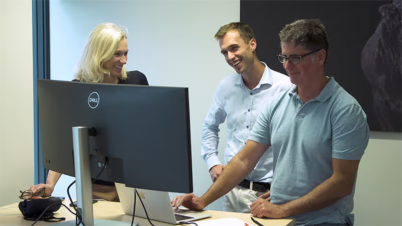 M2X staff stood around a desk talking