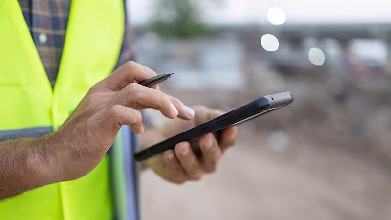 Site worker in high-vis on a tablet