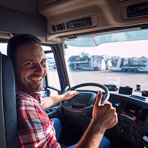Driver sat in truck cab doing thumbs up