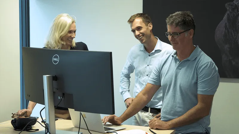 M2X staff stood around a desk talking