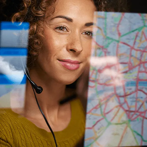 Female dispatcher with headset looking at map on a computer 