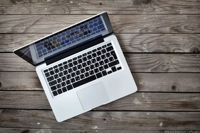 Computer open on wooden table
