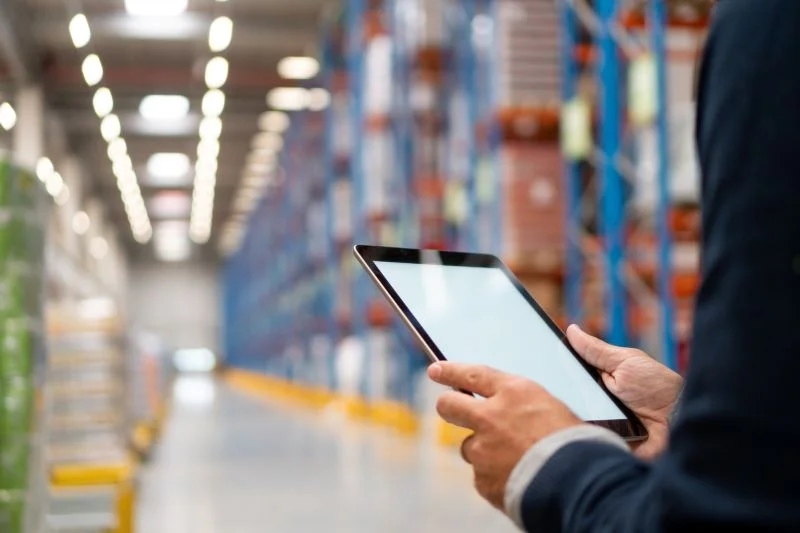 Person holding tablet in warehouse