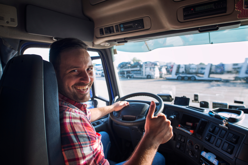 Driver in truck cab with thumbs up