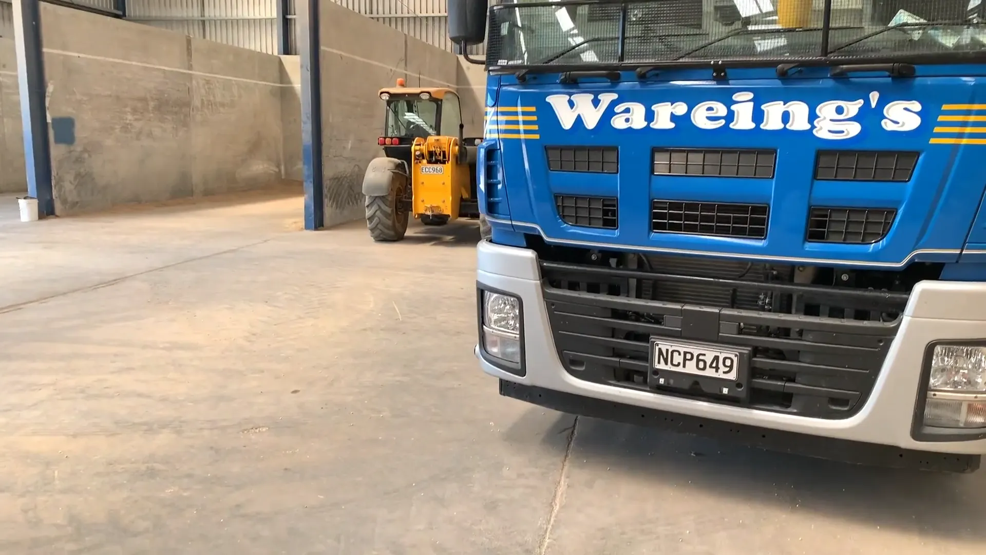 M2X and Phillip Wareing logos over a photo of a Phillip Wareing truck in a shed