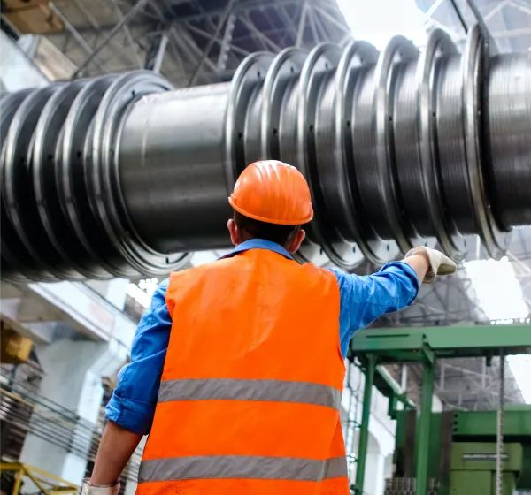 Worker in safety PPE guiding crane